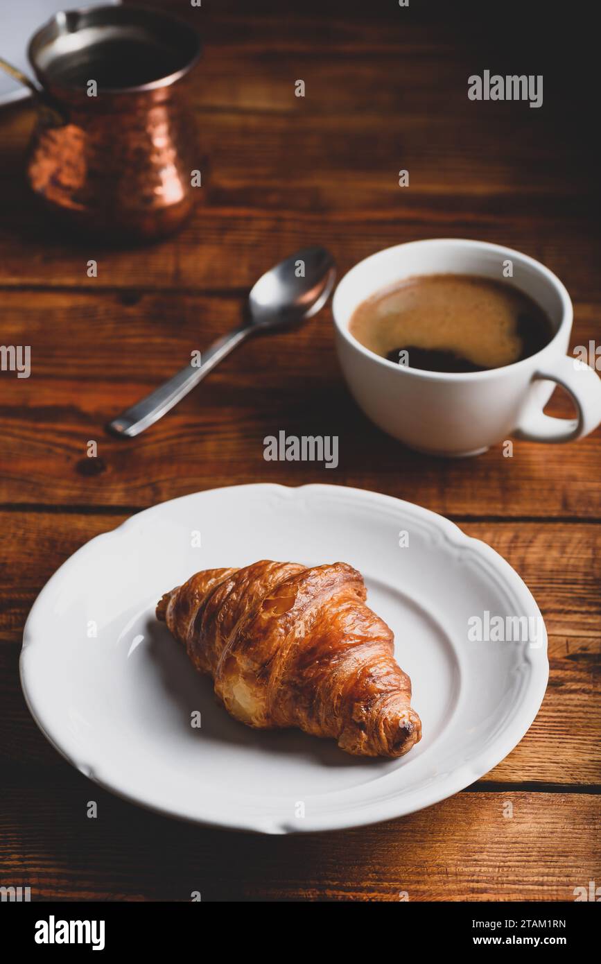 Croissant sur la plaque blanche et une tasse de café turc pour le petit-déjeuner Banque D'Images