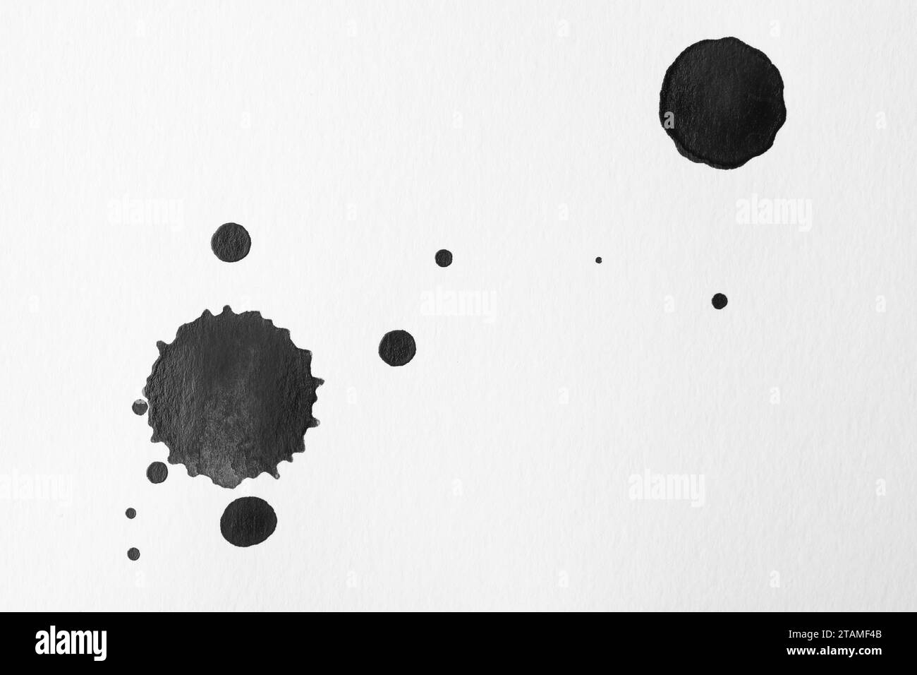 Taches d'encre noire sur fond blanc, pose à plat Banque D'Images