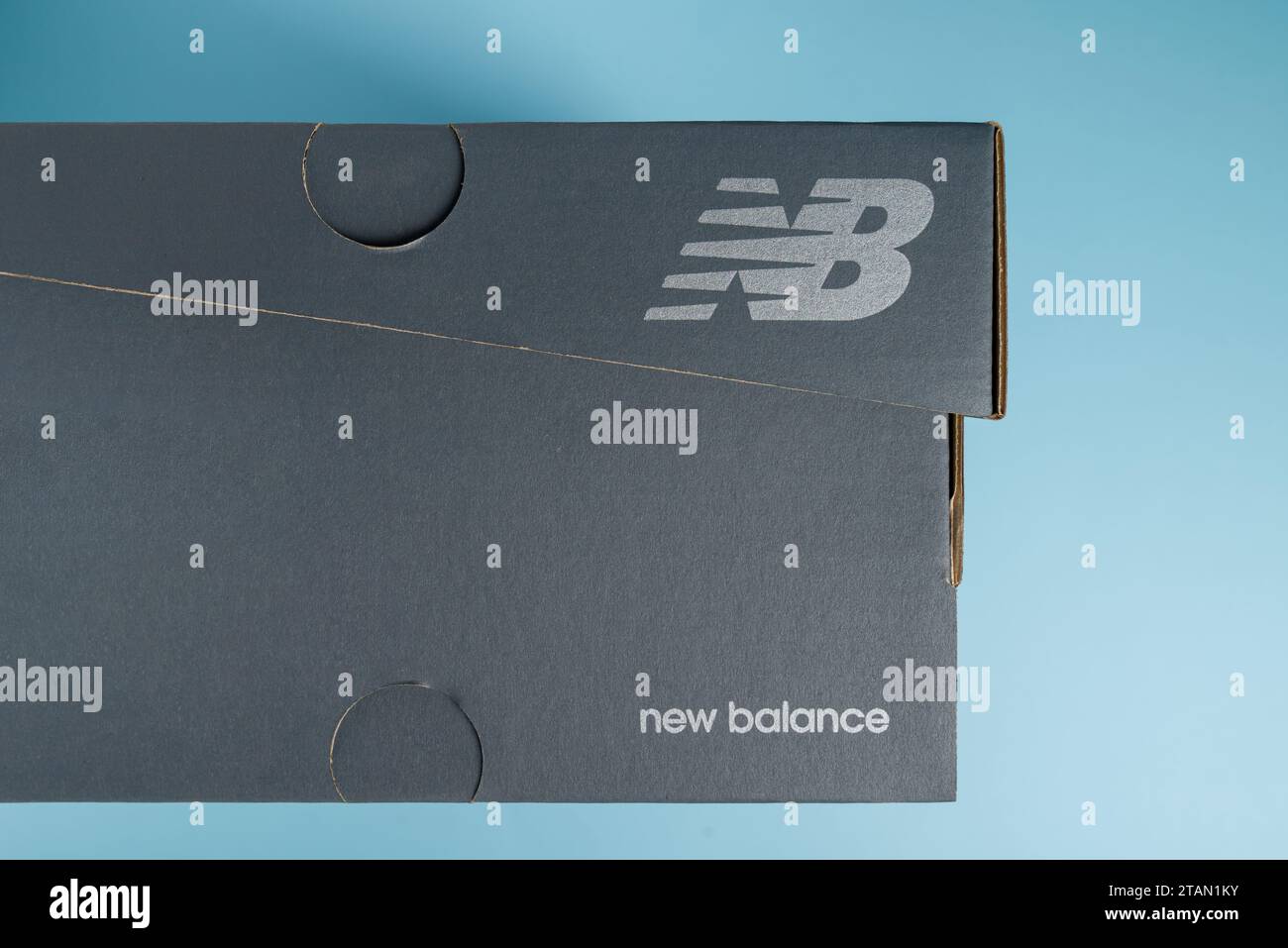 Antalya, Turquie - 1 décembre 2023 : boîte à baskets avec logo New Balance. sur fond bleu Banque D'Images