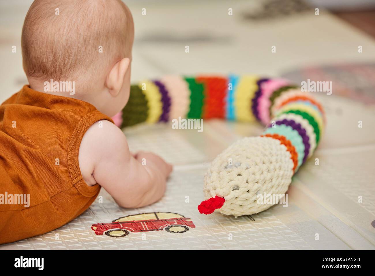 bébé joue avec un jouet tricoté dans la pépinière Banque D'Images