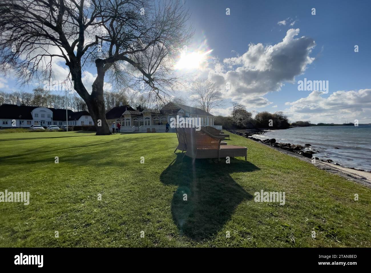 Chaises de pelouse et d'osier pour bronzer au bord de la mer photographié avec le soleil comme une étoile brillante et des lumières de lentille au centre de l'image Banque D'Images