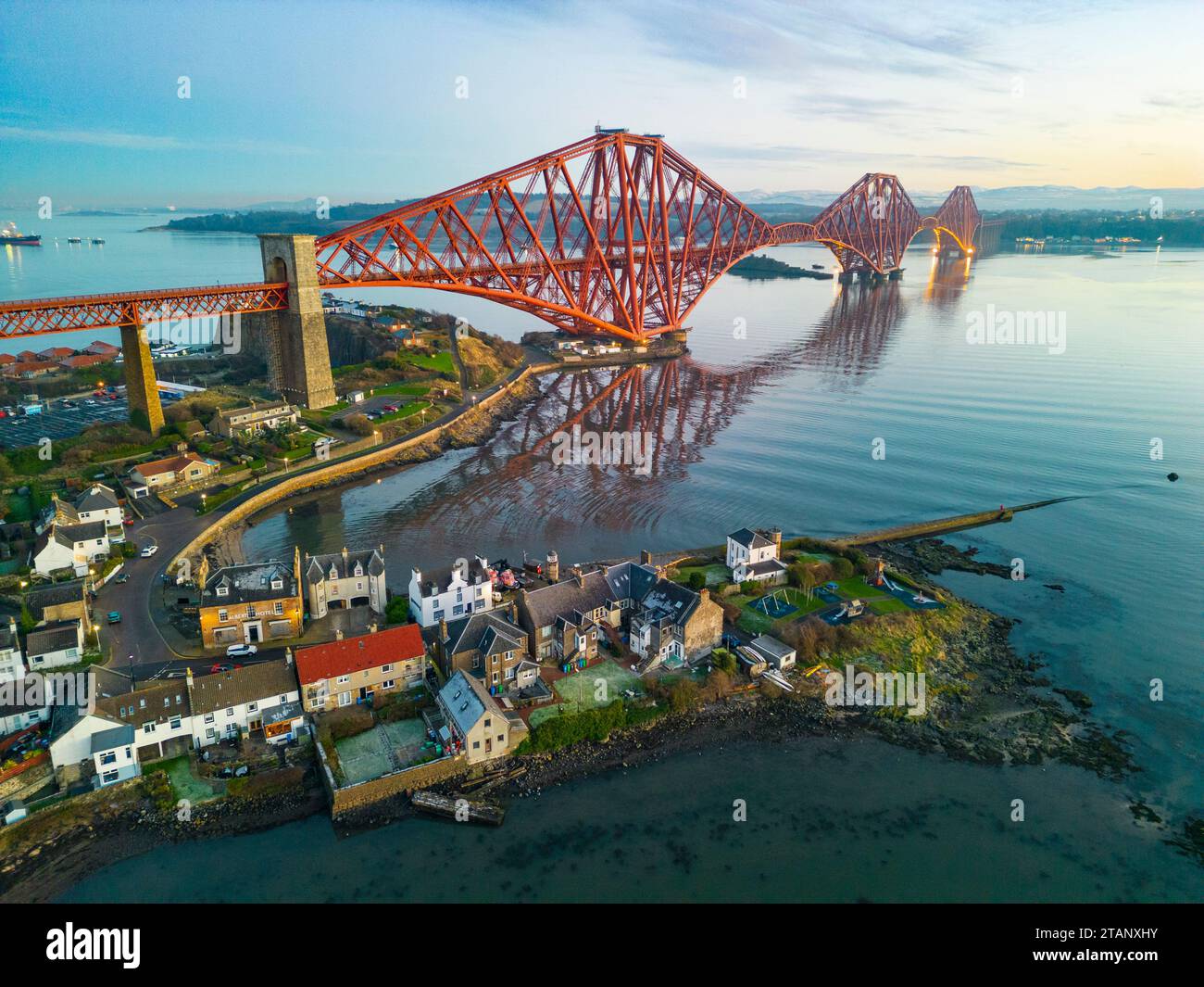 Vue aérienne du drone au crépuscule du village de North Queensferry à côté du Forth Bridge traversant le Firth of Forth, Fife, Écosse, Royaume-Uni Banque D'Images