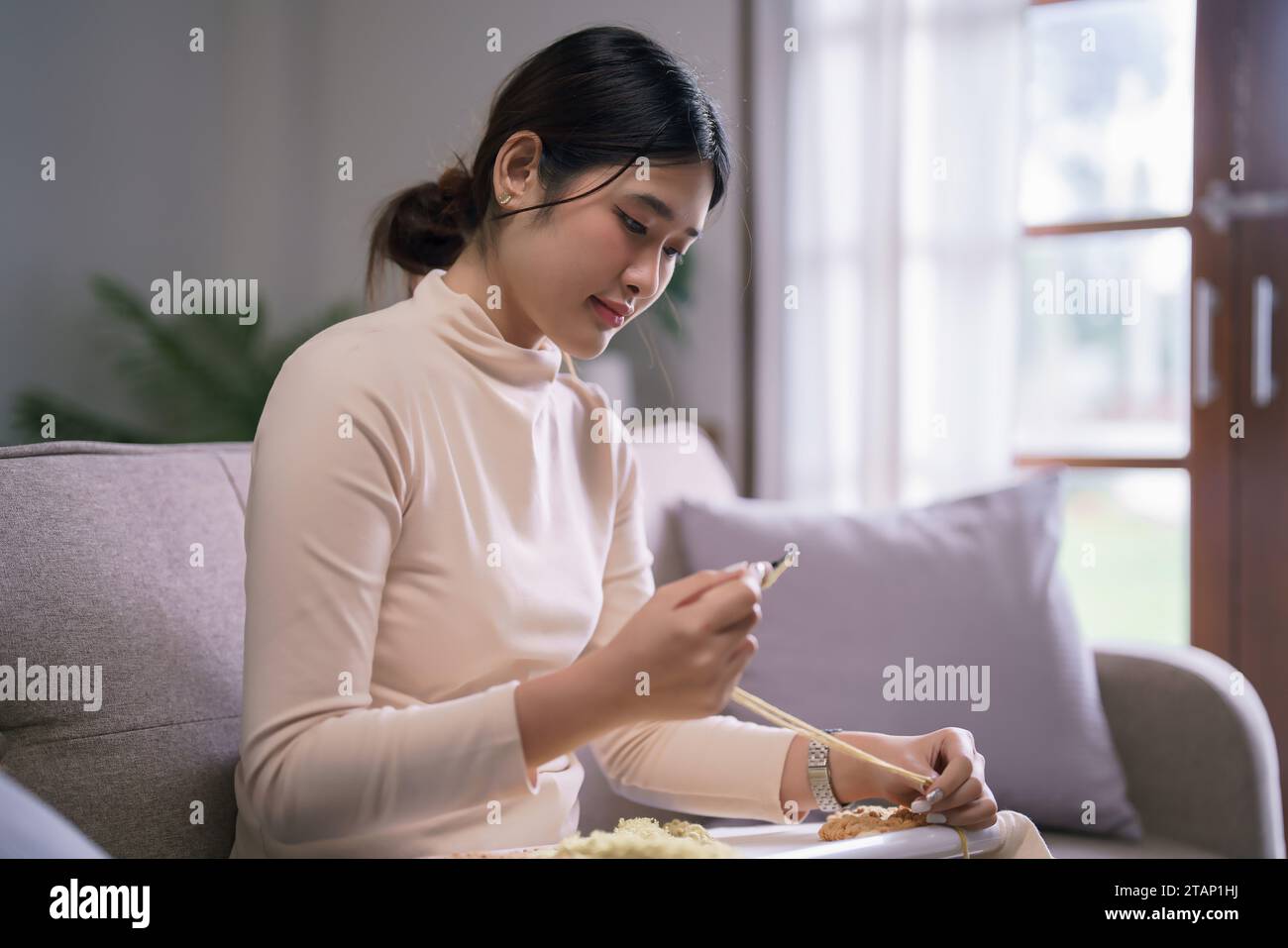 Jeune femme asiatique utilise l'aiguille de poinçon et le fil à l'artisanat de broderie sur le cadre de tissu dans le mode de vie de passe-temps. Banque D'Images