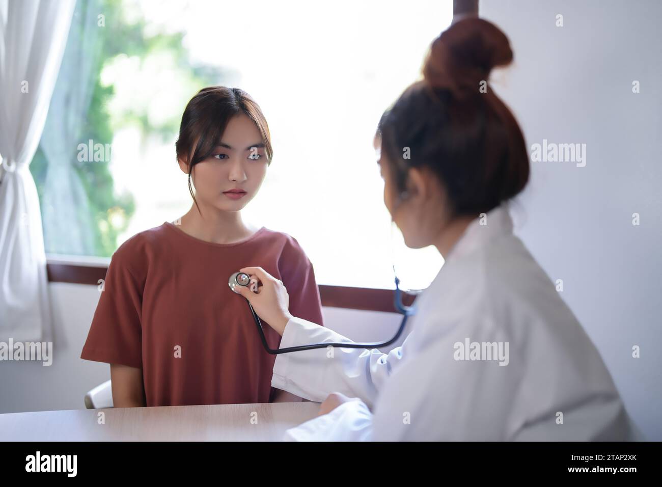 Femmes psychologue asiatique écoutant le rythme cardiaque du patient avec stéthoscope et donnant des conseils sur la thérapie de santé mentale tandis que le stress du patient féminin Banque D'Images