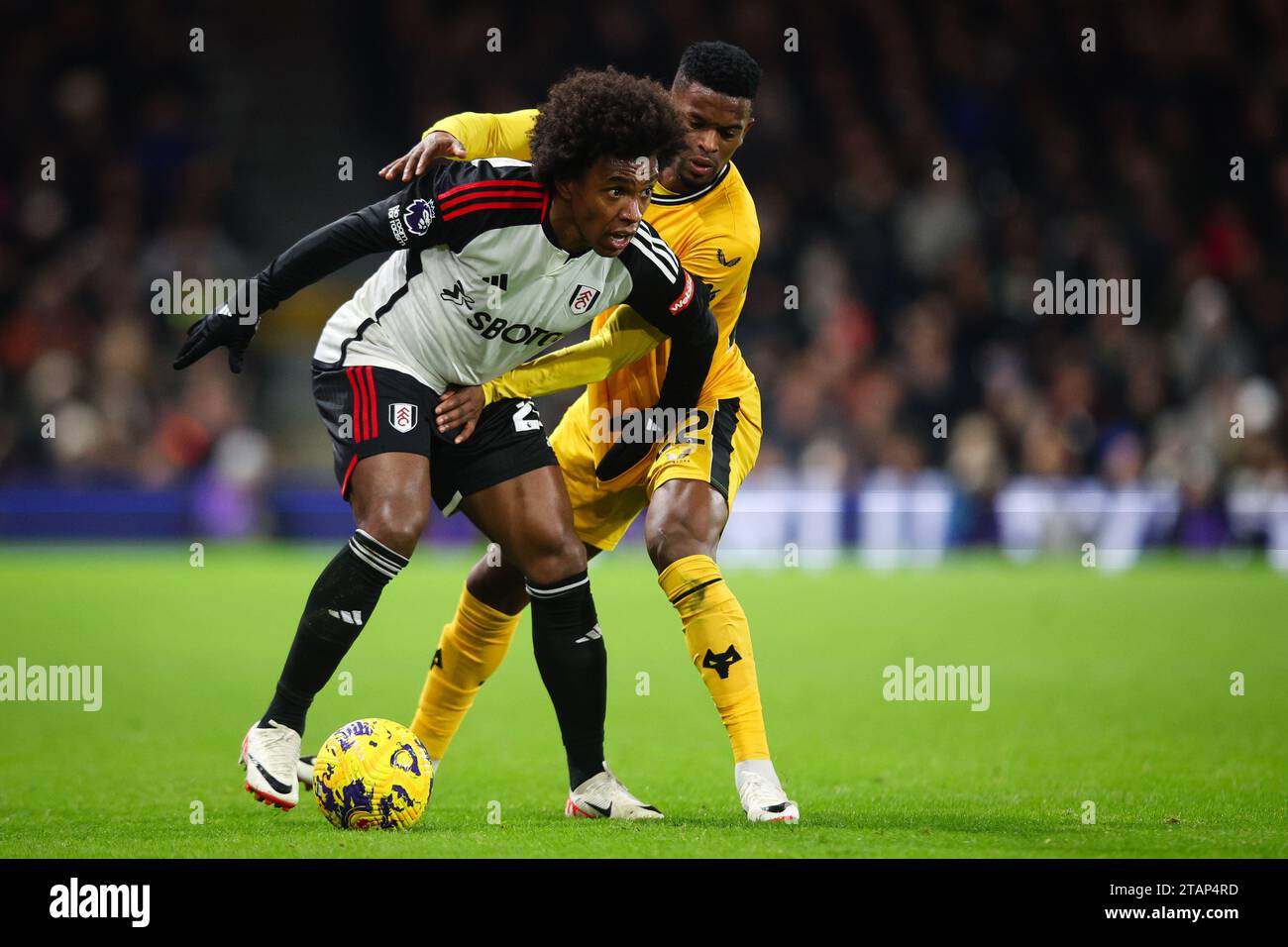 LONDRES, Royaume-Uni - 27 novembre 2023 : Willian de Fulham FC retient le défi de Nelson Semedo de Wolverhampton Wanderers lors de la Premier League matc Banque D'Images