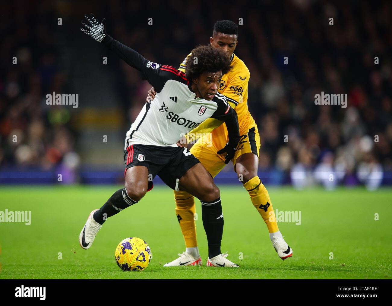 LONDRES, Royaume-Uni - 27 novembre 2023 : Willian de Fulham FC retient le défi de Nelson Semedo de Wolverhampton Wanderers lors de la Premier League matc Banque D'Images