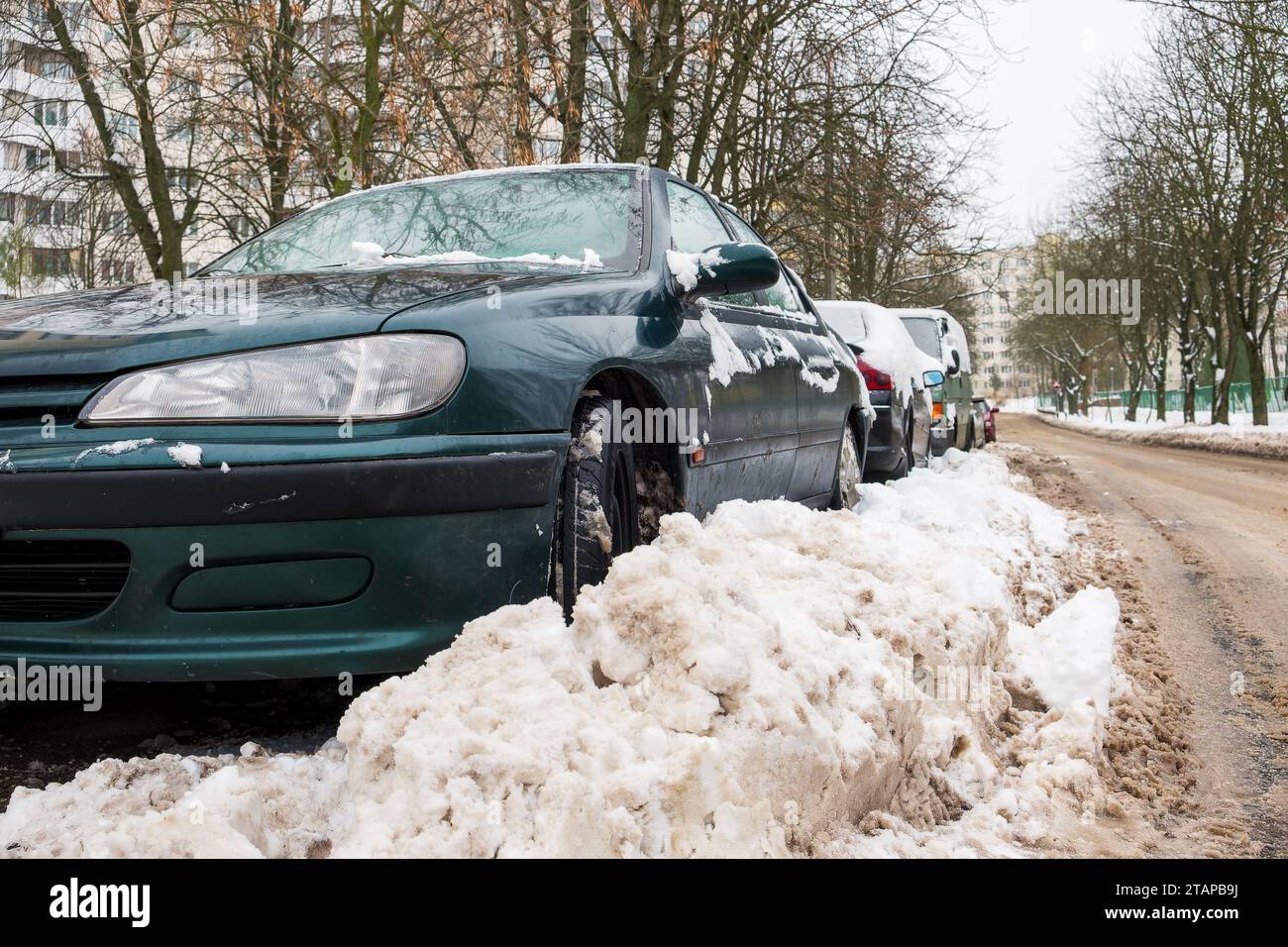 Hiver. La route est couverte de neige. Voitures garées le long du bord de la route et couvertes de neige Banque D'Images