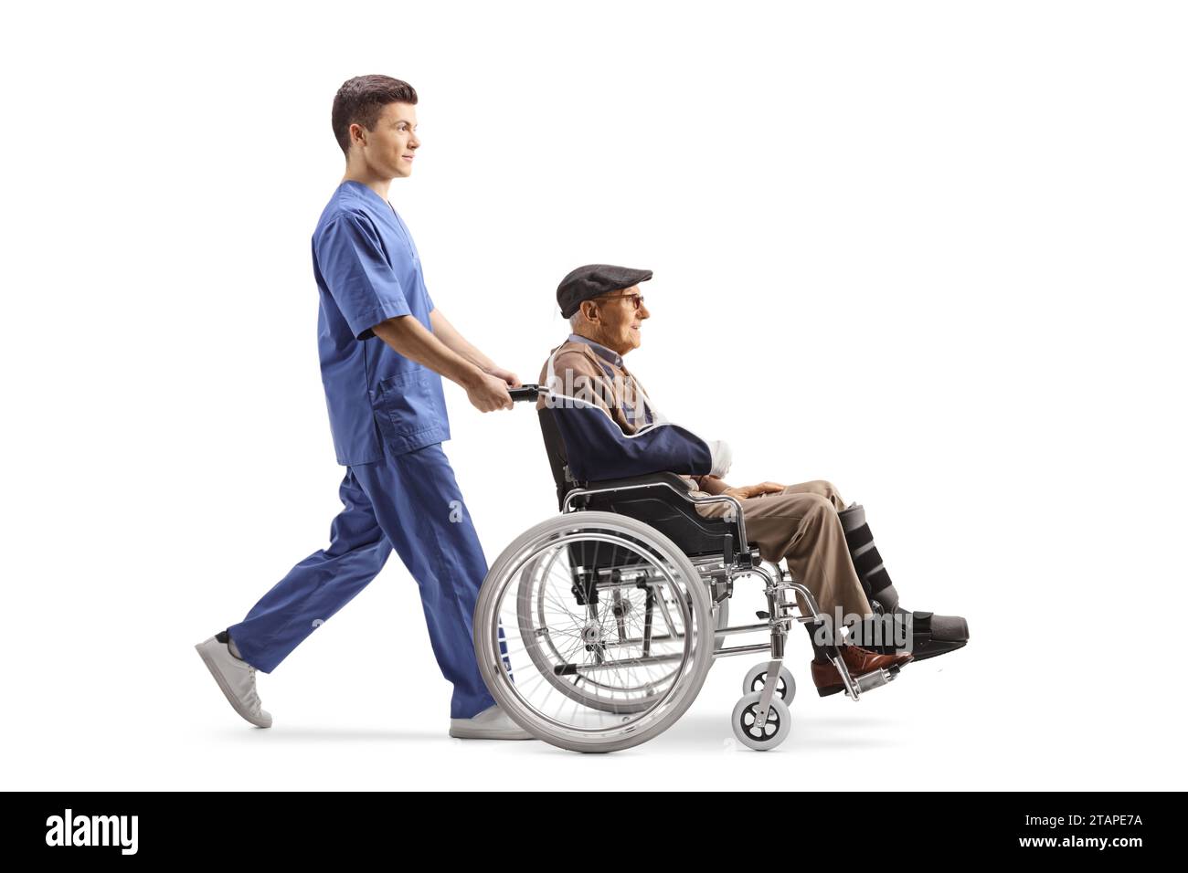 Travailleur de la santé masculin poussant un homme âgé blessé dans un fauteuil roulant isolé sur fond blanc Banque D'Images