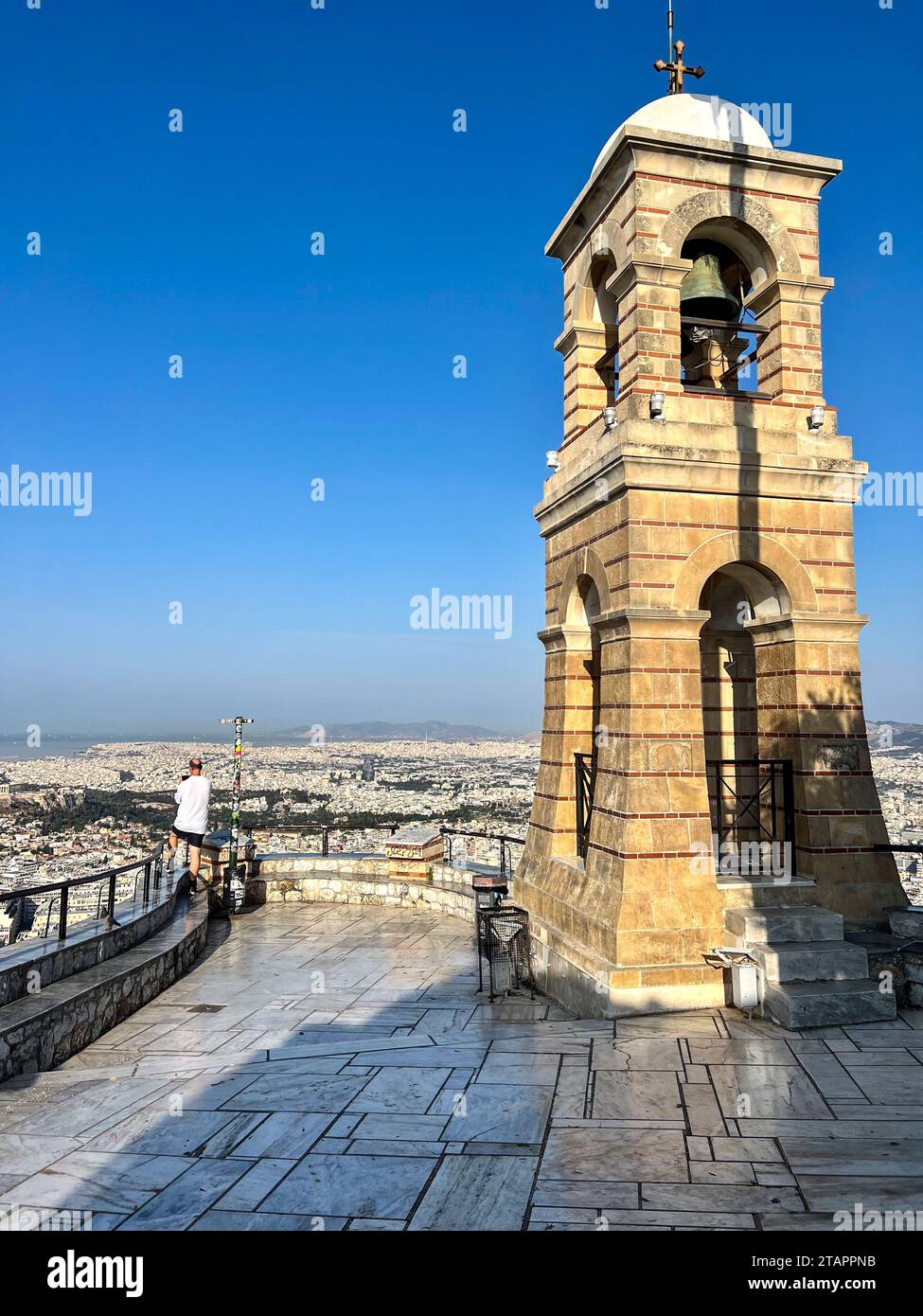 Vue arrière d'un homme prenant une photo du belvédère près du clocher sur le Mont Lycabette, Athènes, Attique, Grèce Banque D'Images
