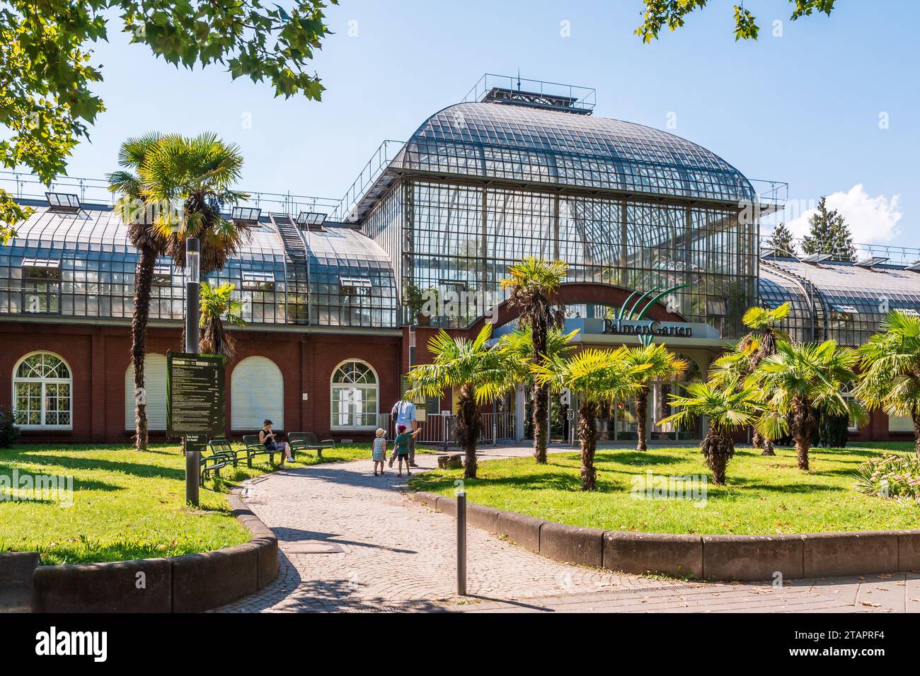 Les gens se dirigent vers l'entrée principale du Palmengarten à Francfort-sur-le-main, en Allemagne, par un après-midi d'été ensoleillé. Banque D'Images