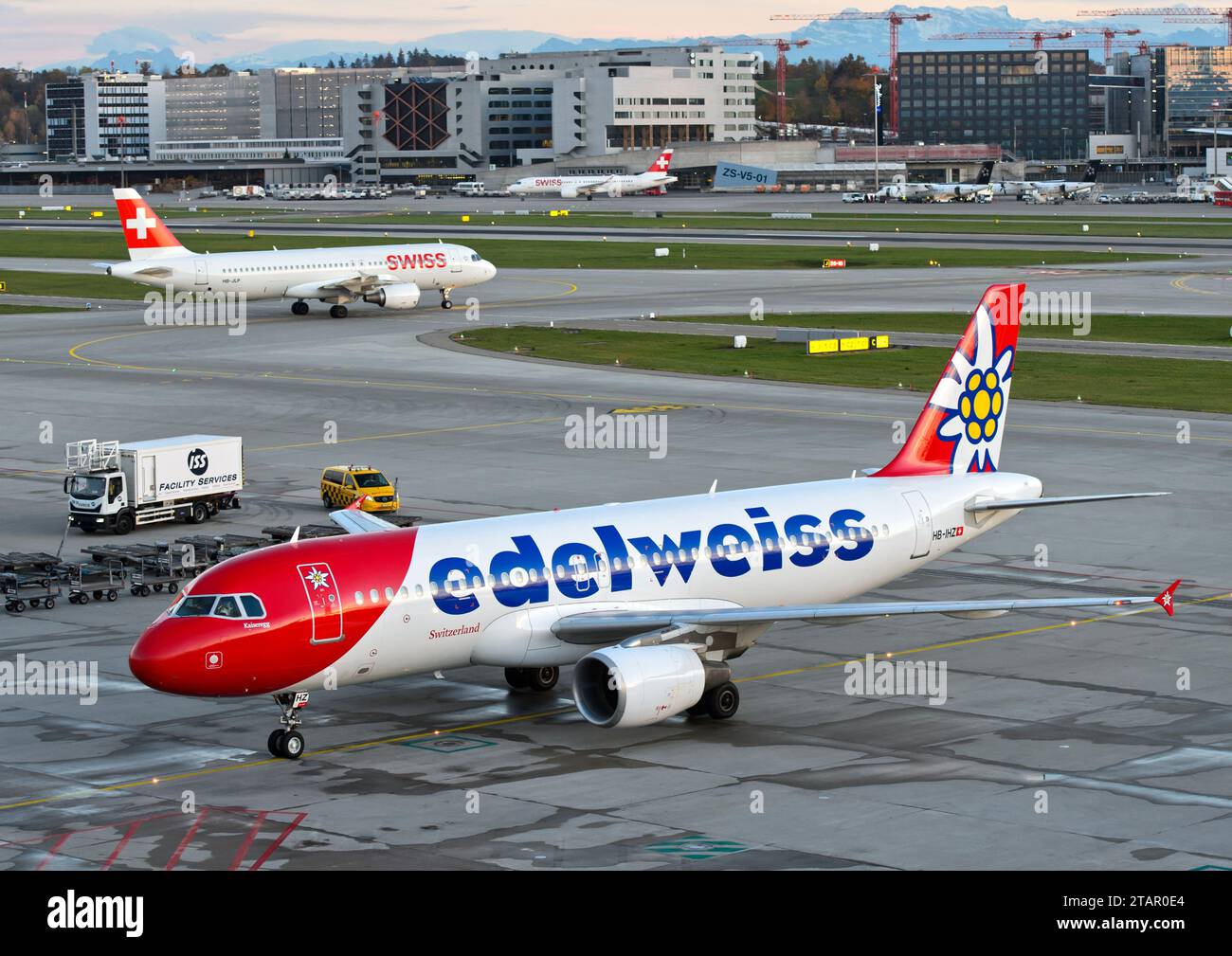 Airbus de la compagnie aérienne suisse de loisirs Edelweiss Air, derrière un avion de Swiss International Air Lines sur la piste, aéroport de Zurich, Suisse Banque D'Images