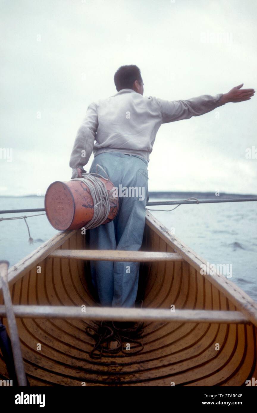 CHURCHILL, MB - JUILLET 1954 : un homme se tient à la tête du bateau lors d'une expédition de chasse à la baleine vers juillet 1954 à Churchill, Manitoba, Canada. (Photo de Hy Peskin) Banque D'Images