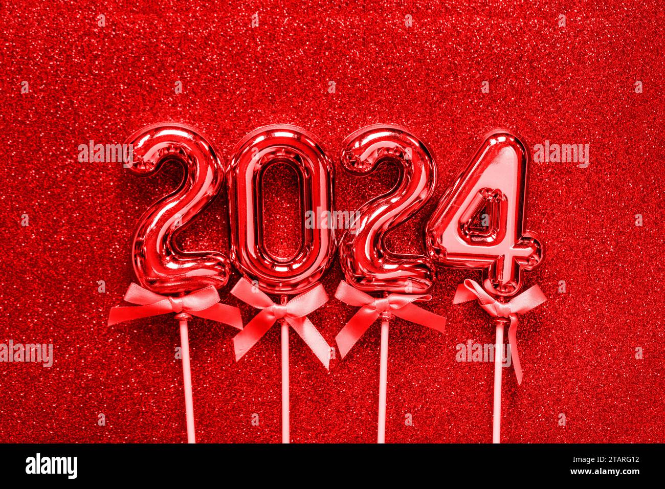 2024 Happy New Year concept - vieux numéros rouges sur fond gris de paillettes de poussière de métal photo stock Banque D'Images