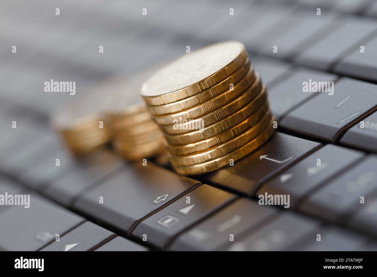 Piles de pièces sur un clavier d'ordinateur. Concept d'achat en ligne Banque D'Images