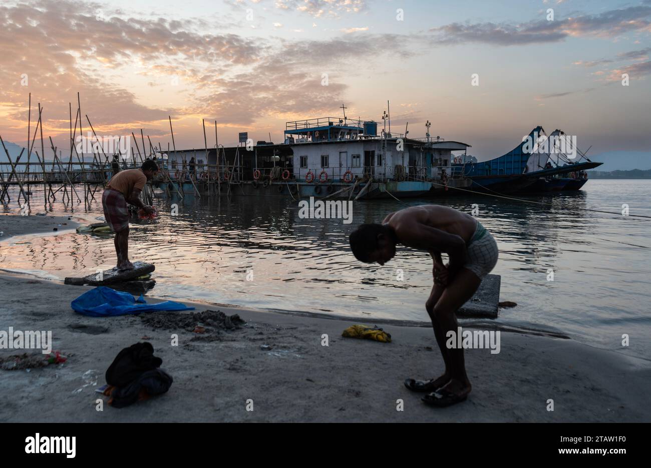 Les gens prennent un bain sur la rive de la rivière Brahmapoutre pendant Sunset, à Guwahati, Assam, Inde le 2 décembre 2023. Crédit : David Talukdar/Alamy Live News Banque D'Images