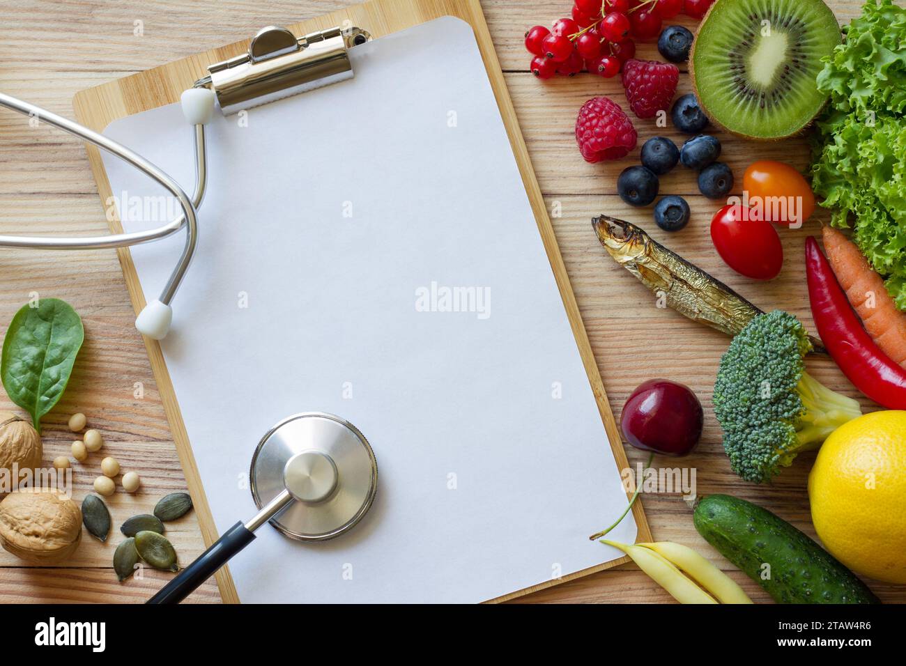 Fruits et légumes frais, noix, poissons, légumineuses et cahier vide avec stéthoscope sur fond en bois. Alimentation saine et concept d'alimentation équilibrée Banque D'Images