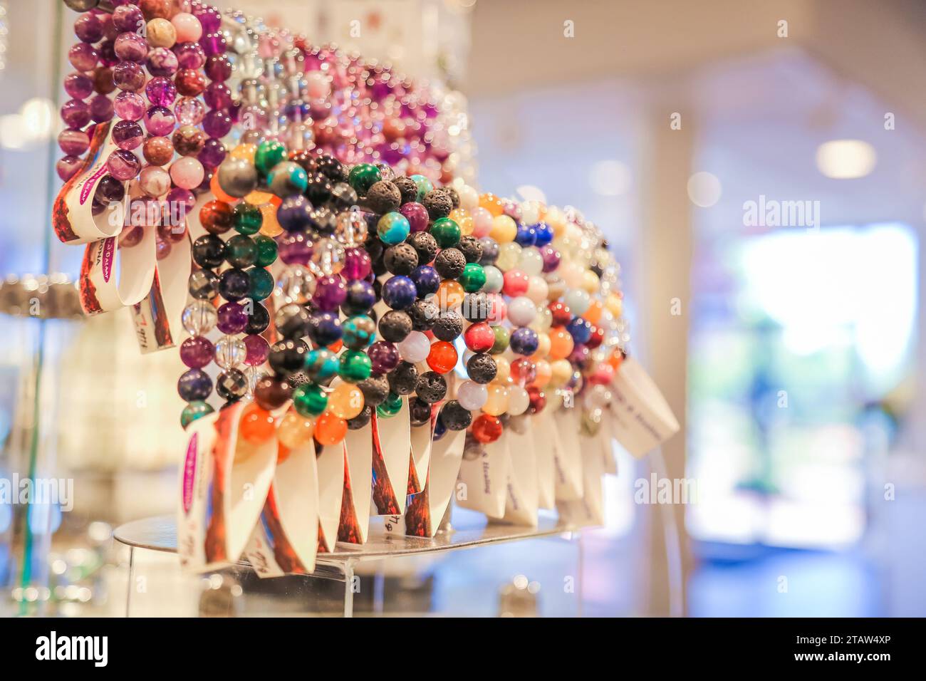 Un gros plan de bracelets avec des pierres précieuses colorées dans une boutique Banque D'Images