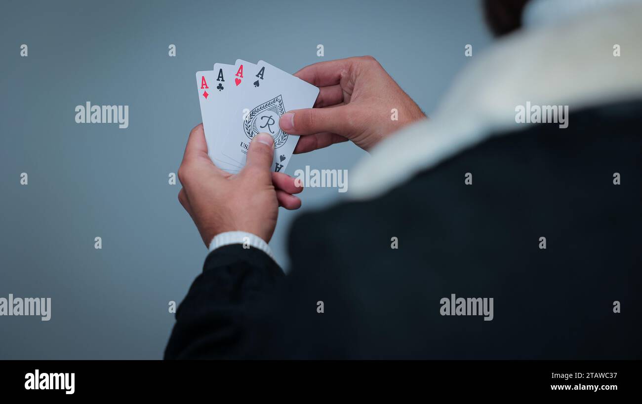 Jeune homme tenant des cartes sur fond gris, Focus sur les cartes, cartes à jouer Banque D'Images