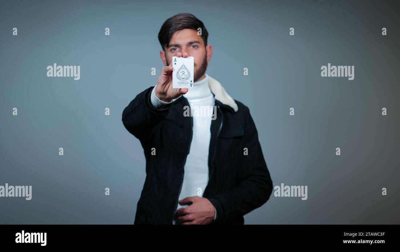 Jeune homme tenant des cartes sur fond gris, Focus sur les cartes, cartes à jouer Banque D'Images