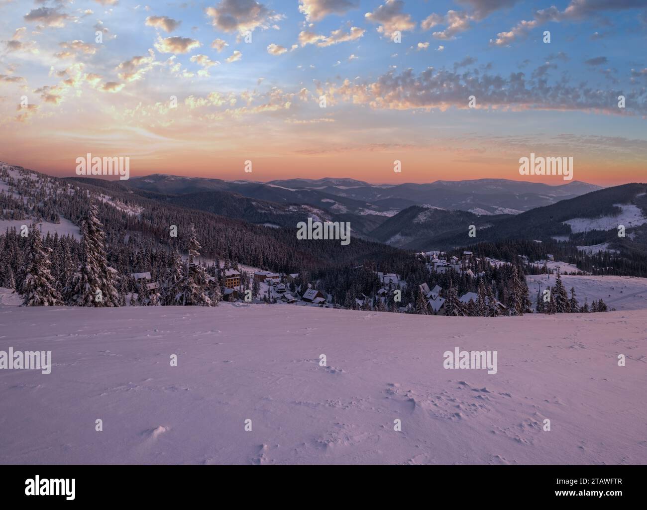 Pittoresque matin d'hiver avant le lever du soleil sur les alpes. Vue sur la célèbre station de ski ukrainienne Dragobrat depuis la crête de Svydovets. Banque D'Images