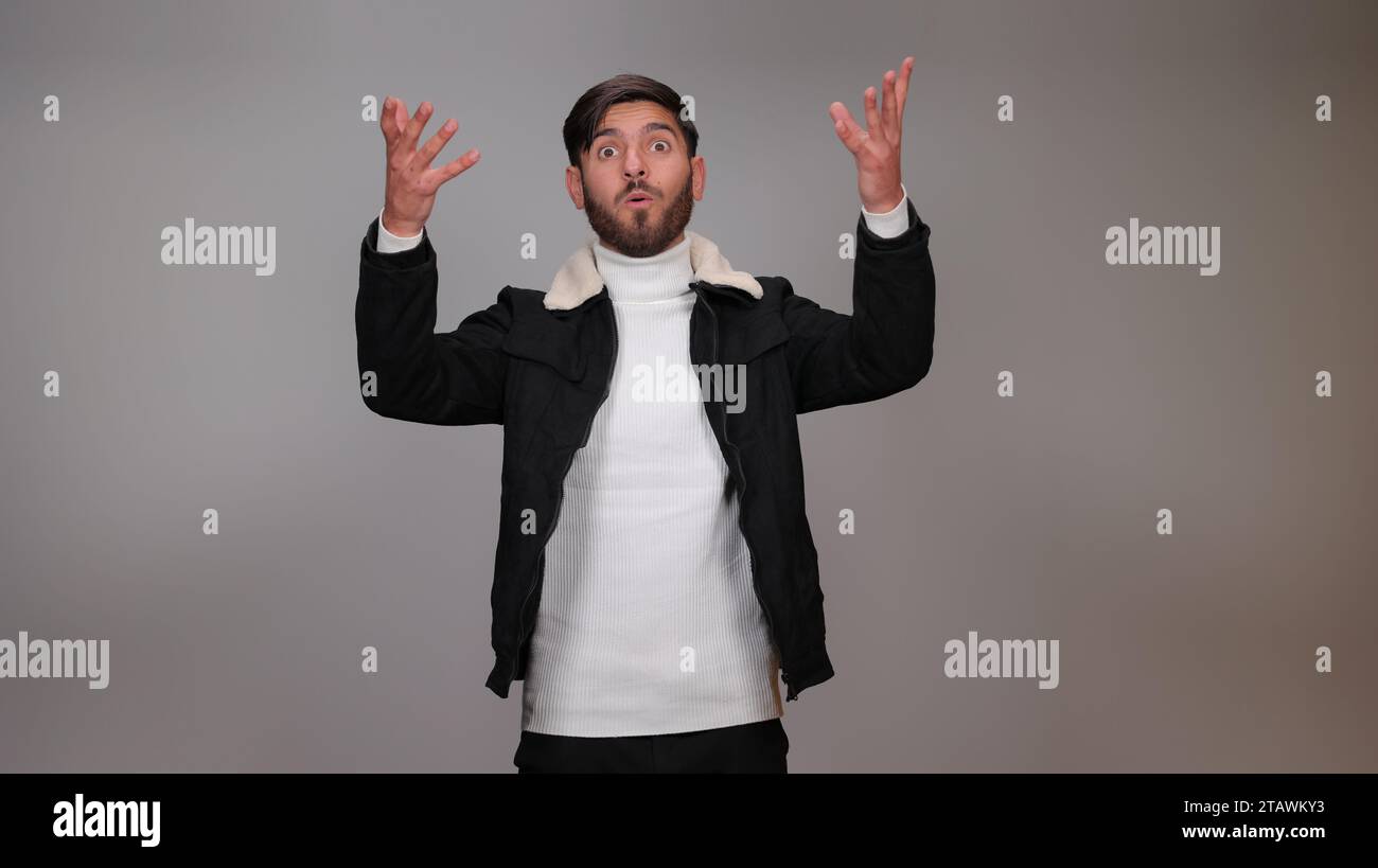 L'homme riche a jeté tout l'argent et ils volent autour. Intérieur, studio shot, isolé sur fond gris. Banque D'Images
