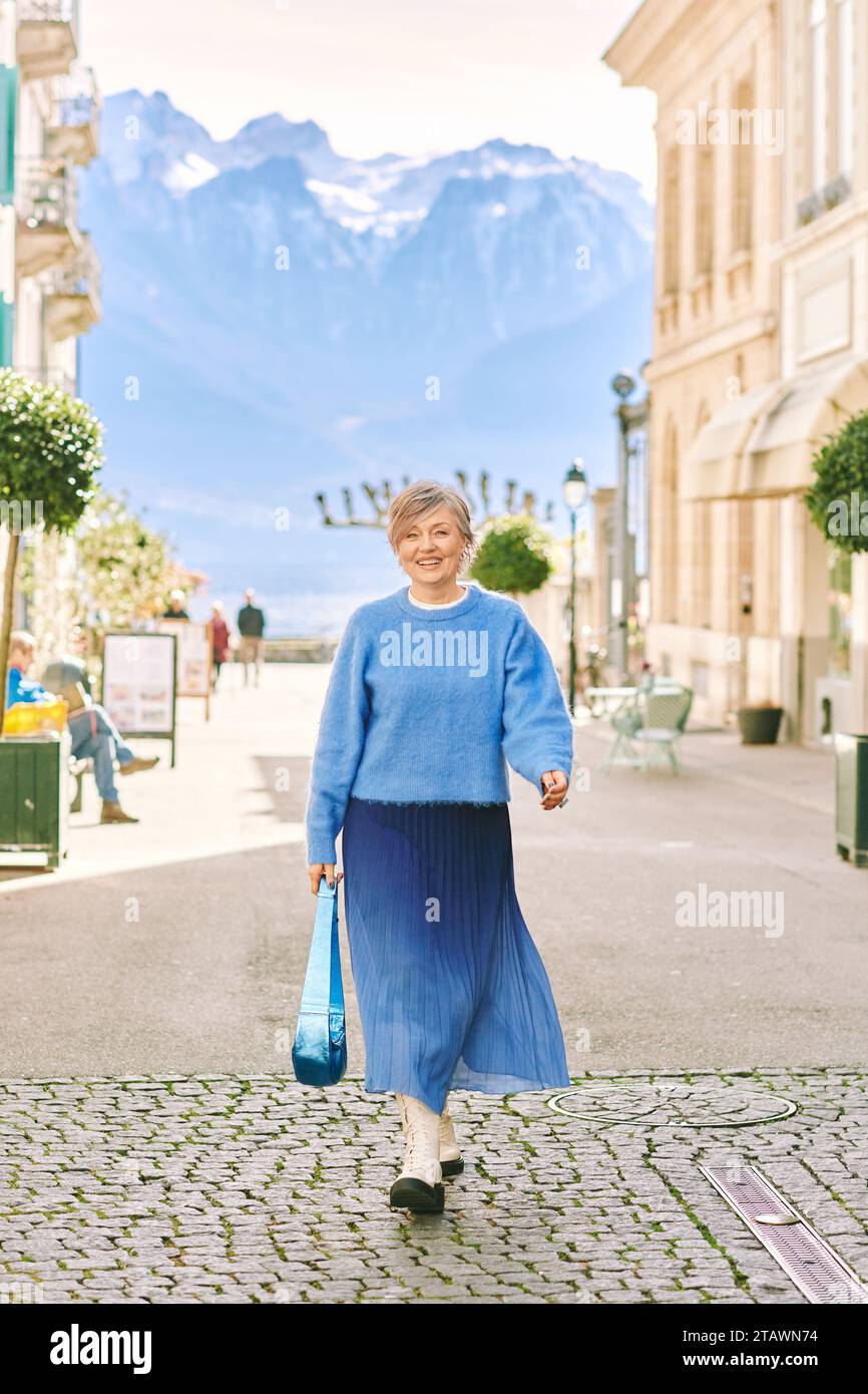 Portrait en plein air de belle femme d'âge moyen 55 - 60 ans posant à l'extérieur, portant pull bleu et jupe Banque D'Images