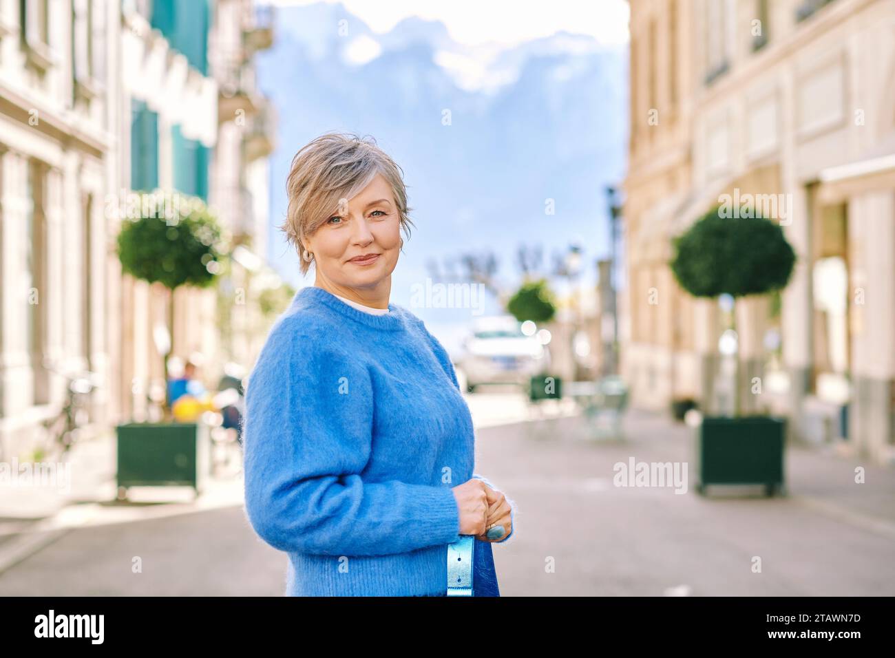 Portrait en plein air de belle femme d'âge moyen 55 - 60 ans posant à l'extérieur, portant un pull-over bleu Banque D'Images