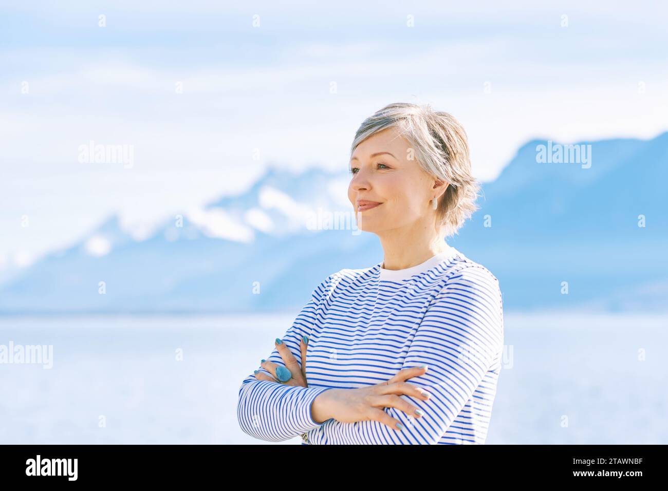 Portrait en plein air de belle femme mature posant à côté du lac, portant un t-shirt rayé bleu, mode de vie sain Banque D'Images