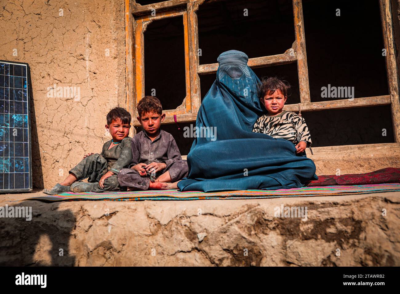 Une veuve triste dans le besoin, accompagnée de ses enfants, représente des familles afghanes confrontées à la pauvreté et aux difficultés | Refugee Family. Banque D'Images