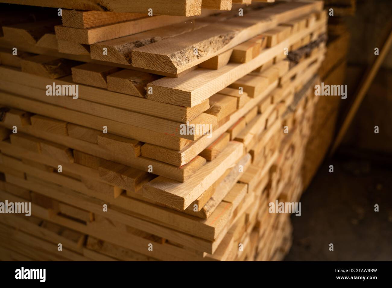 Planches de bois empilées en gros plan dans un entrepôt de bois extérieur. Arrière-plan des planches. Industrie du bois Banque D'Images