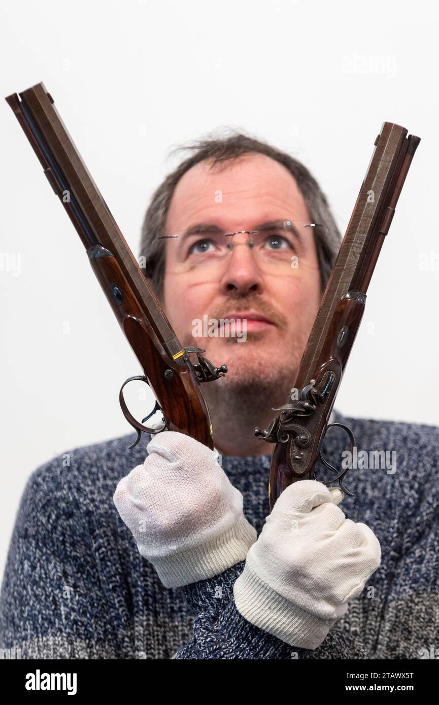 Londres, Royaume-Uni. 3 décembre 2023. Un membre du personnel présente « Une paire de pistolets duels à silex 36 bore », 1816-20, par le fabricant londonien Durs Egg, armurier de George IV, (environ £14,000-18,000) lors d'un aperçu des faits saillants de la prochaine vente d'armes, d'armures et de militaria à Olympia Auctions dans l'ouest de Londres. La vente a lieu le 6 décembre. Crédit : Stephen Chung / Alamy Live News Banque D'Images