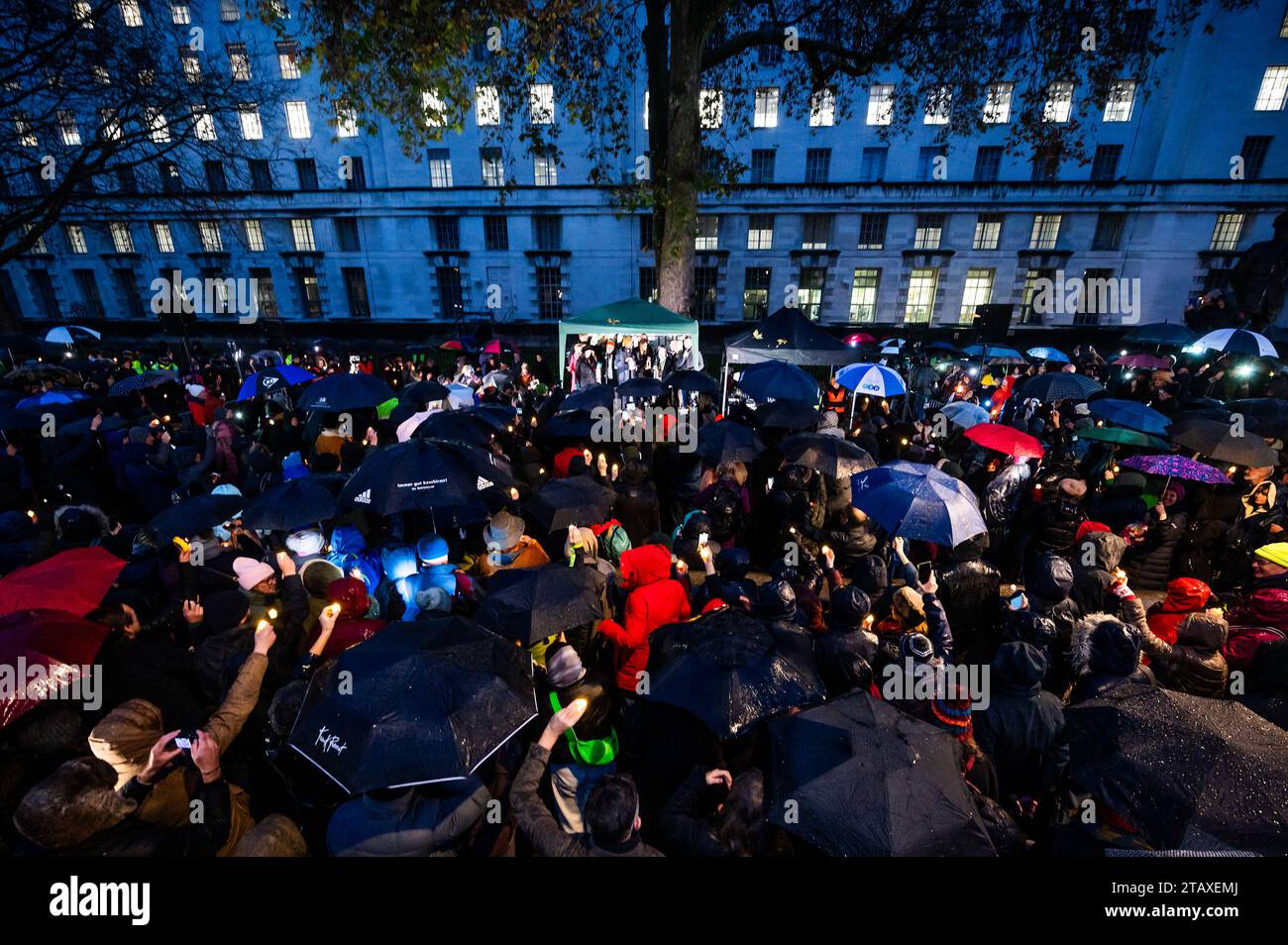 Londres, Royaume-Uni. 3 décembre 2023. Des bougies et un téléphone ont été tenus en l'air en souvenir - Building Bridges, Together for Humanity, un rassemblement à l'extérieur de Downing Street pour « dénoncer à la fois l'antisémitisme et la haine anti-musulmane ». Le rassemblement a vu des dirigeants religieux et des politiciens rejoindre des familles en deuil « dans le premier événement de masse de ce genre » depuis que les militants du Hamas ont attaqué Israël le 7 octobre. La veillée a eu lieu avec un bcakdrop du ministère de la Défense et les statues des maréchaux Montgomery et Slim. Crédit : Guy Bell/Alamy Live News Banque D'Images