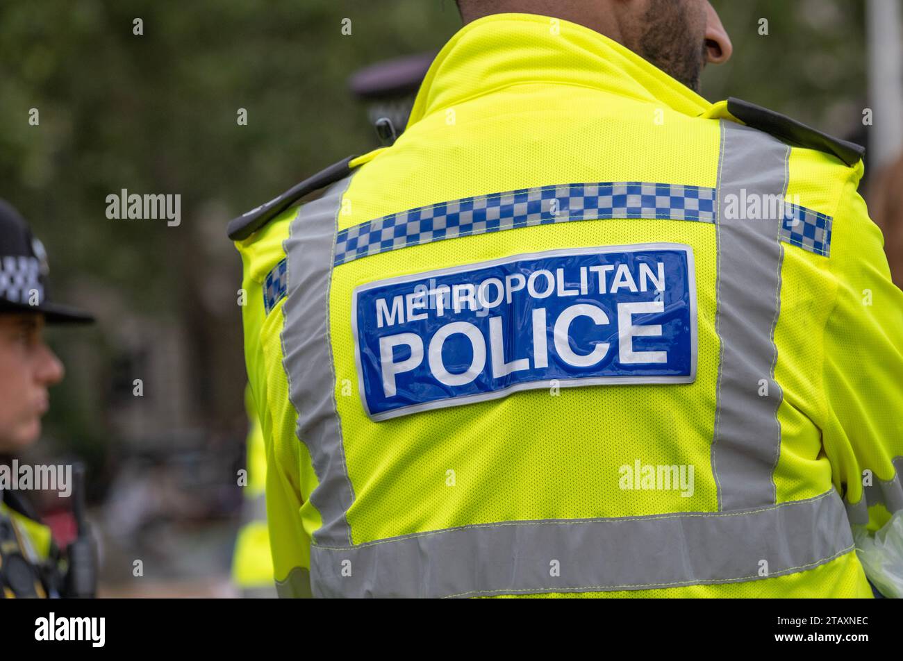 Metropolitan police signe au dos d'une veste haute visibilité portée par les policiers surveillant une manifestation de protestation dans la rue à Londres. Banque D'Images