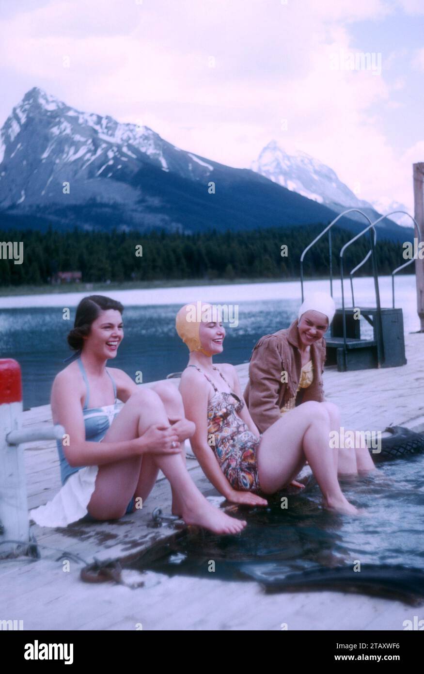 JASPER, AB - JUILLET 1954 : vue générale alors que trois femmes s'assoient près d'une piscine d'eau pendant leur promenade sur le sentier Jasper vers juillet 1954 à Jasper, Alberta, Canada. (Photo de Hy Peskin) Banque D'Images