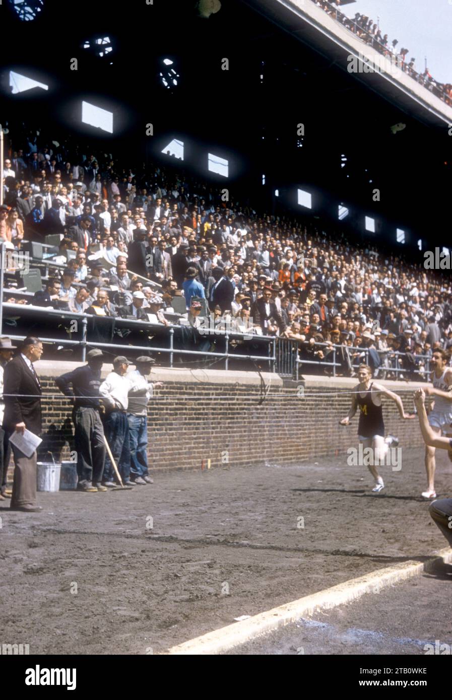 PHILADELPHIE, PA - 25 AVRIL : les athlètes universitaires courent vers la ligne d'arrivée lors des relais d'athlétisme le 25 avril 1958 au Franklin Field à Philadelphie, Pennsylvanie. (Photo de Hy Peskin) Banque D'Images