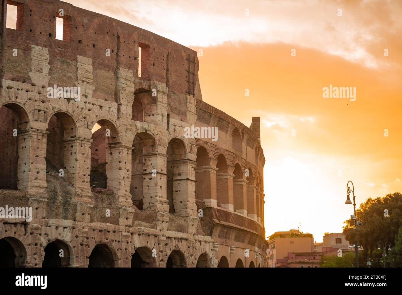 Vue matinale du colisée à Rome, ciel rouge et bleu avec soleil sur le point de se lever au-dessus du grand amphithéâtre célèbre. Réglage d'automne. Banque D'Images