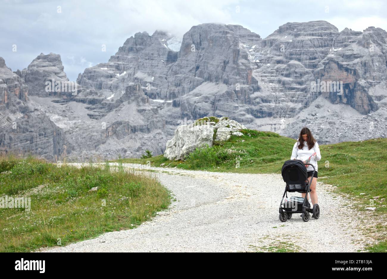 Femme avec buggy dans les montagnes, Dolomites Italie Banque D'Images