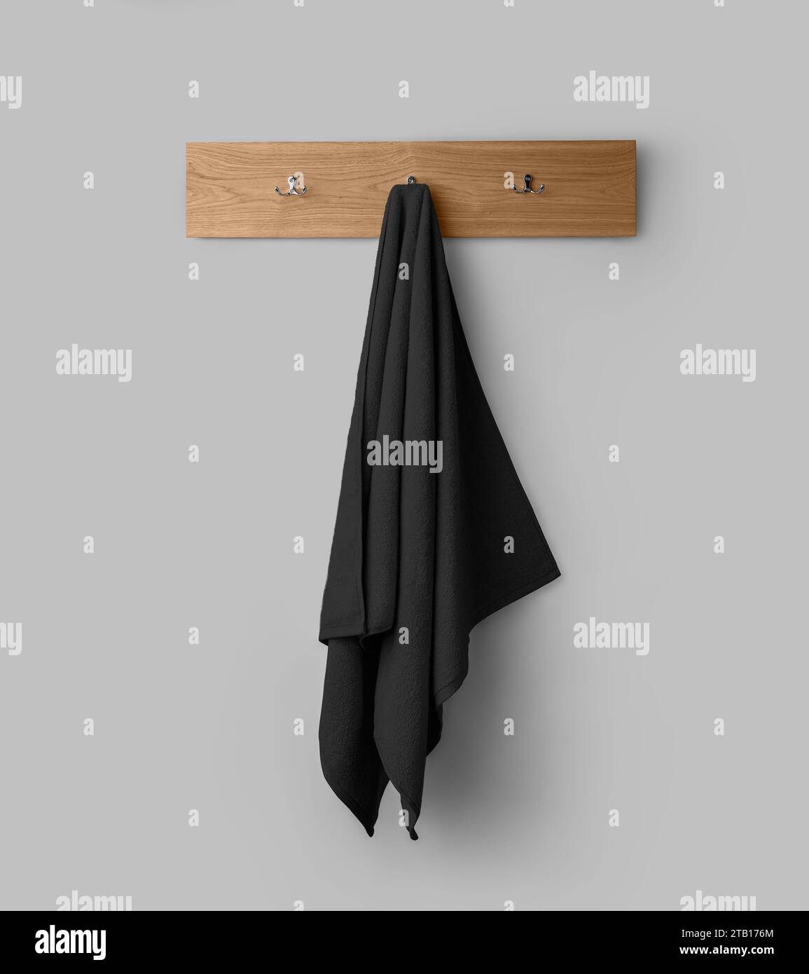 Maquette d'une serviette noire éponge sur un cintre en bois, serviette suspendue pour la conception, l'image de marque, la présentation. Décoration intérieure pour essuyer. Modèle de serviette isola Banque D'Images