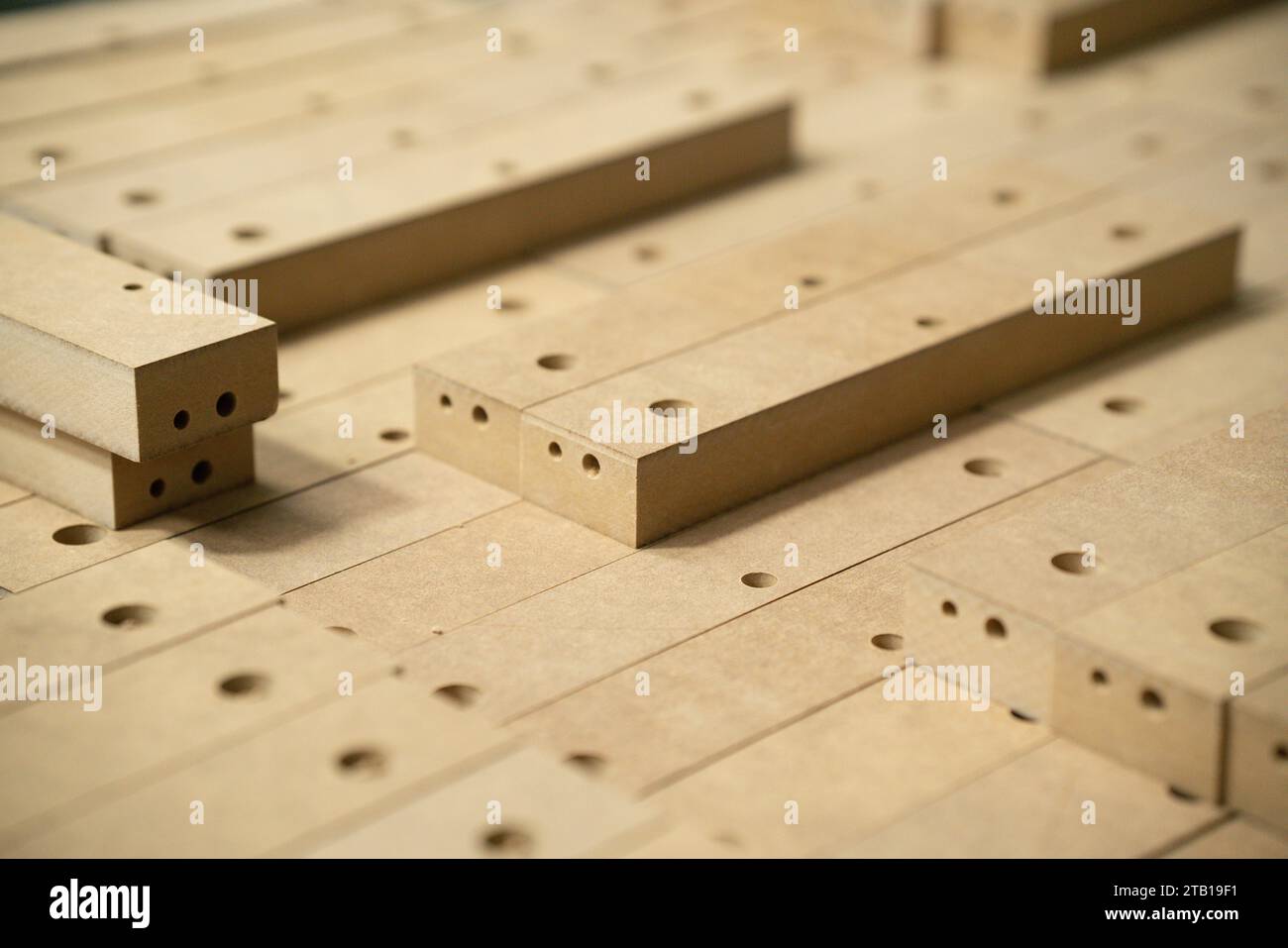 Gros plan des pièces en bois dans les grandes installations de fabrication de meubles. Pièces en bois pour la production de chaises dans l'entrepôt d'une usine de meubles Banque D'Images