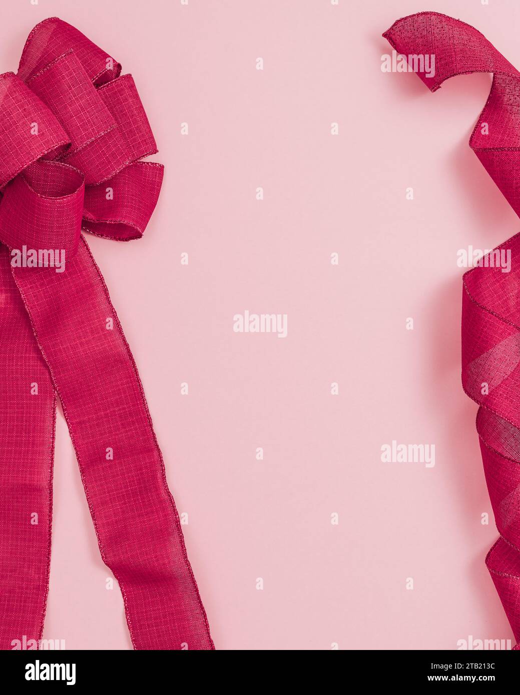 Ruban rouge de noël et arc sur fond rose avec copie Banque D'Images