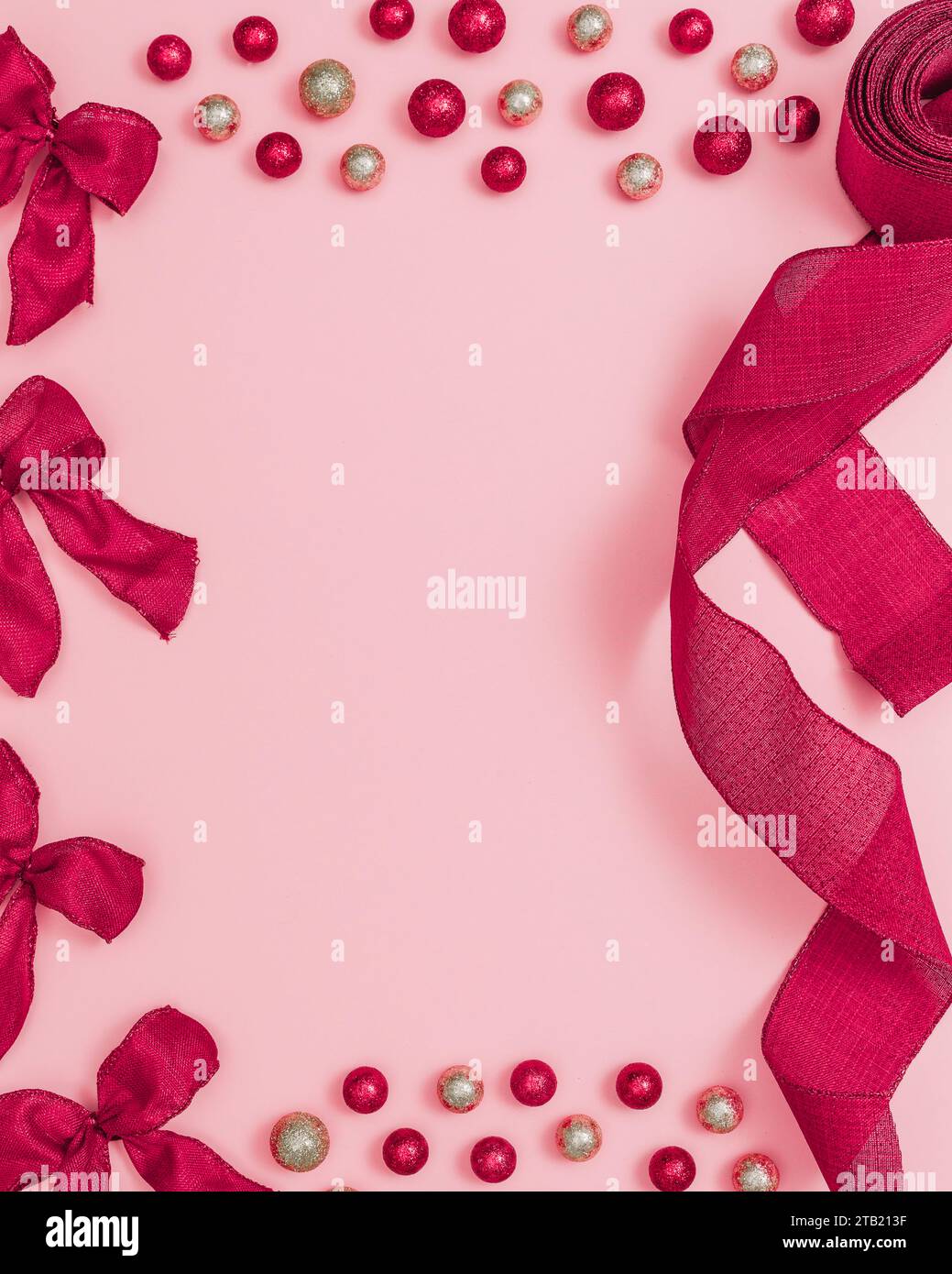 Ruban rouge et boucles sur fond rose avec ornements et espace de copie Banque D'Images