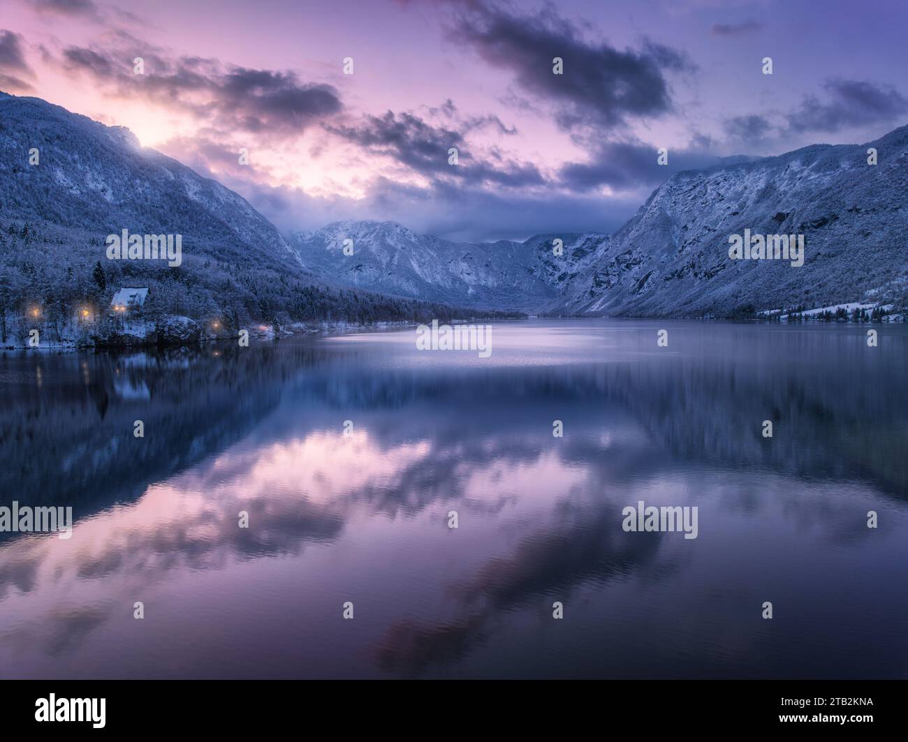 Vue aérienne du lac, montagnes enneigées, arbres, ciel violet la nuit Banque D'Images