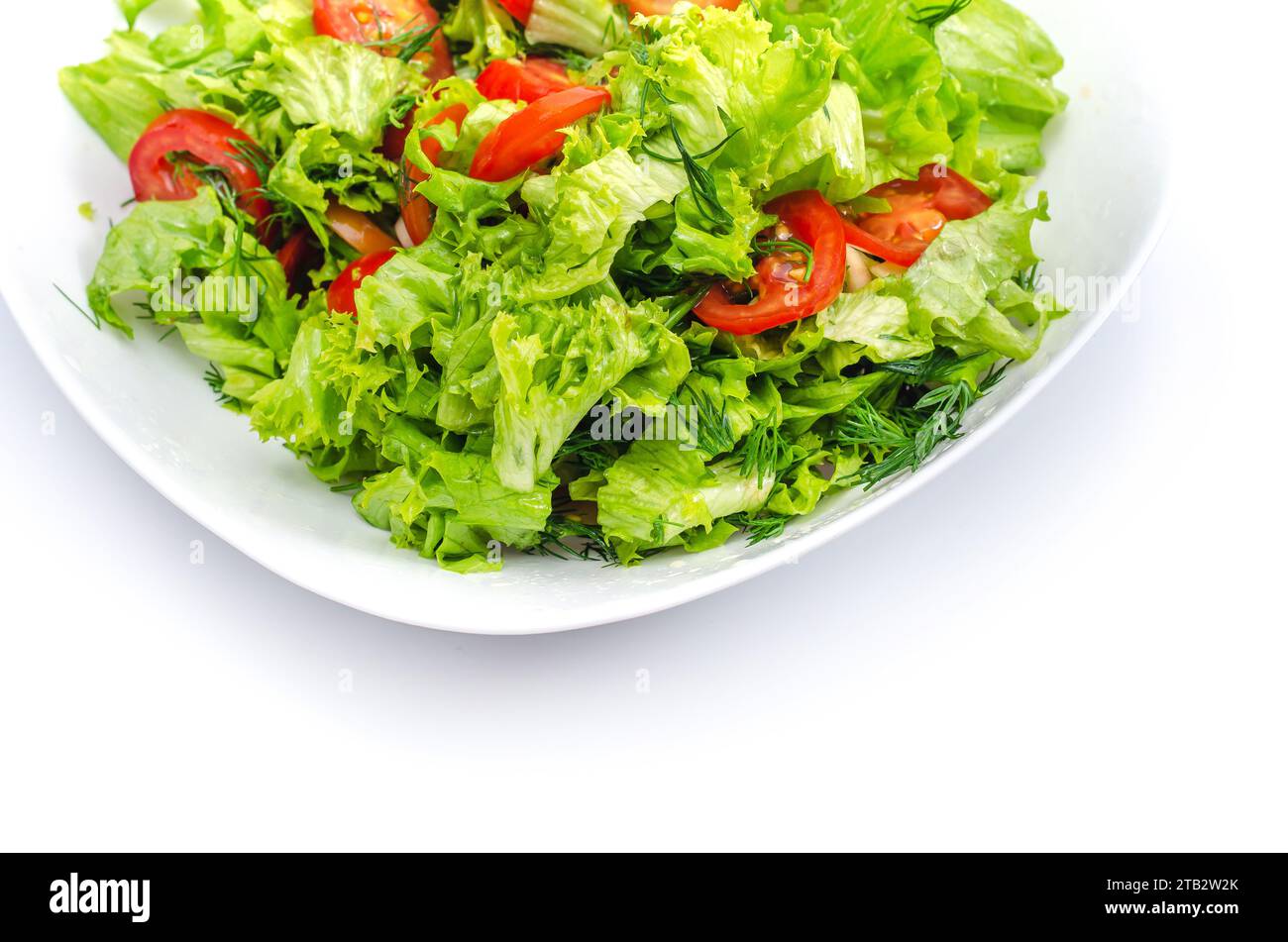 Bol blanc de légumes hachés - aneth, tomates, laitue. Fond blanc, isolé, espace de copie Banque D'Images