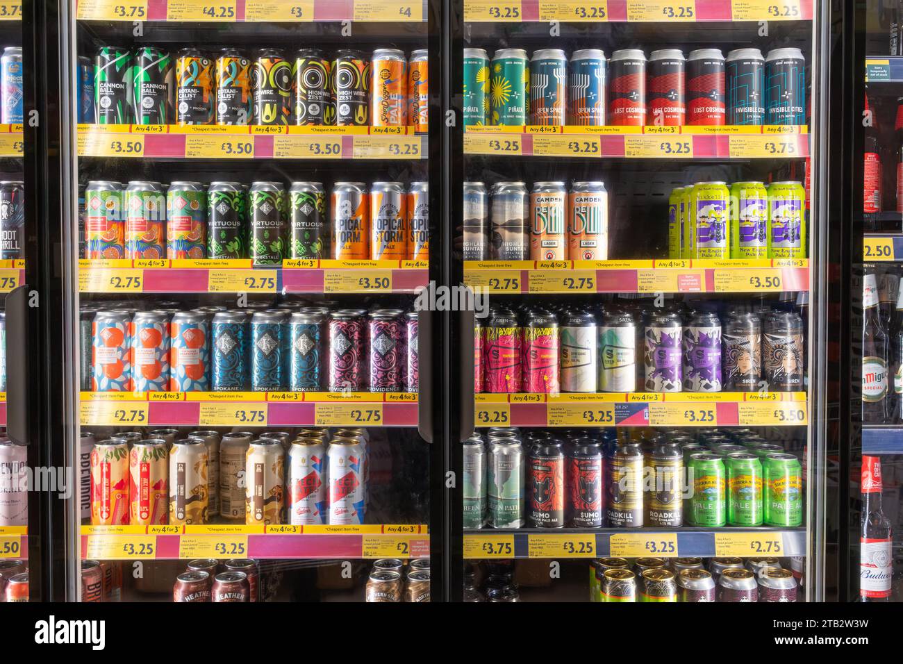 Une collection colorée et variée de bières artisanales britanniques et internationales froides en canettes en vente dans les réfrigérateurs au supermarché Morrisons, en Angleterre Banque D'Images