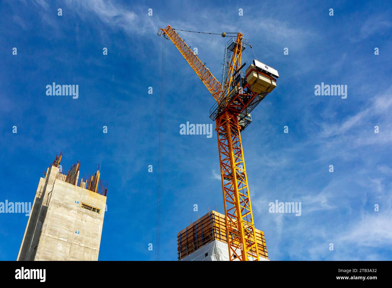 Bâtiments de grande hauteur en construction avec grue et ciel bleu en arrière-plan. Banque D'Images