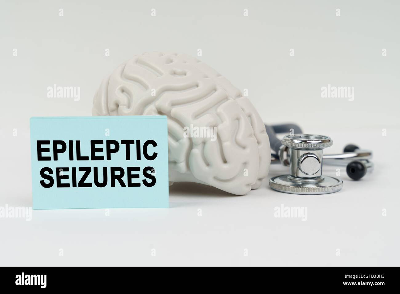 Concept médical. Sur une surface blanche à côté du cerveau, il y a un stéthoscope et des autocollants avec l'inscription - crises d'épilepsie Banque D'Images
