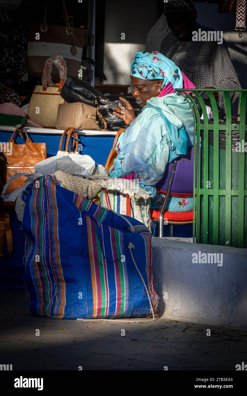 Dame en costume traditionnel africain vendant des marchandises à un stand de marché. Costa Teguise, Lanzarote, Îles Canaries, Espagne. Banque D'Images