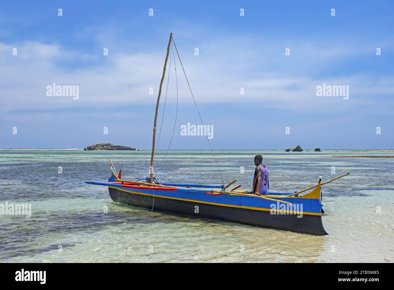 Pêcheur malgache traînant un bateau de pêche traditionnel en bois / canoë à balancier à Andavadoaka près de Morombe, région Atsimo-Andrefana, Madagascar Banque D'Images