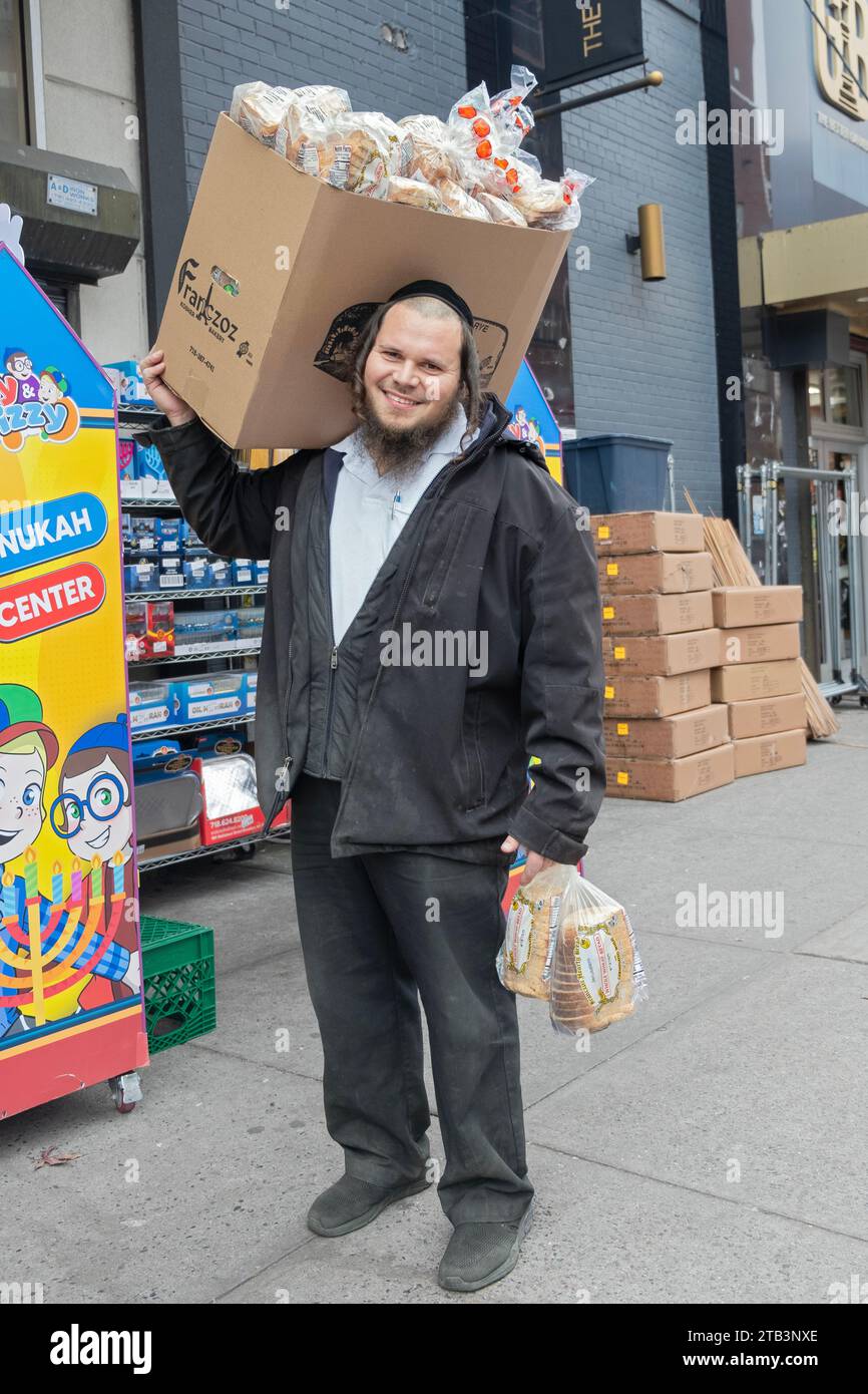 Photo posée d'un ouvrier juif orthodoxe qui livre du pain Franczoz dans un supermarché Glatt Kosher à Williamsburg, Brooklyn, New York. Banque D'Images