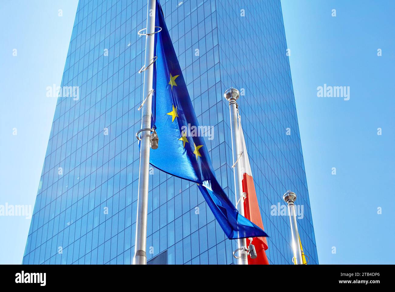 Drapeaux polonais et européens de l'Union, volant et agitant avec fond de bâtiment de bureau de mur de verre Banque D'Images